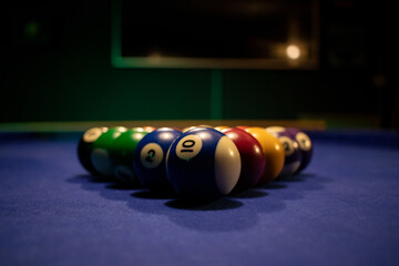 billiard balls arranged on the blue table to start the game