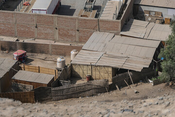 Huaycan - Peru, group of concrete houses in a town among the desert hills.