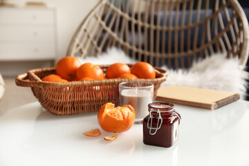 Aroma candles with tangerines on table in room