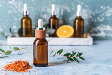 Bottle of saffron essential oil on color background