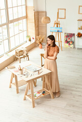 Young female artist drawing in workshop