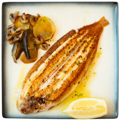 Grilled common sole served with wedge of fresh lemon and vegetable garnish of baked potato,...