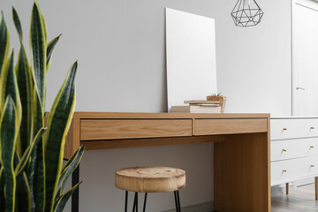 Modern wooden table with decor near light wall in living room