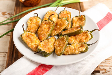 Plate with delicious jalapeno poppers on table, closeup
