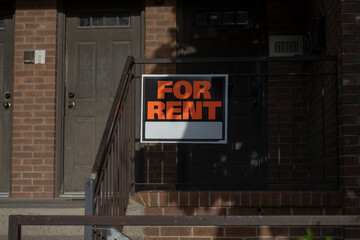 Sign for rent at the front of a residential house. Affordable housing, real estate crisis,...
