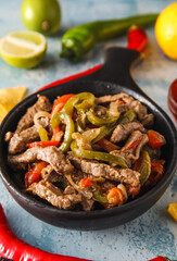 Frying pan with tasty Fajita on color background, closeup