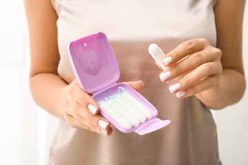 Woman taking tampon from plastic storing box, closeup