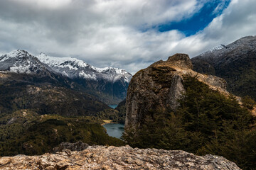 A small lake surrounded by mountains and forests