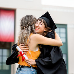 Friends hugging at graduation ceremony