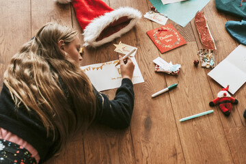 Kids writing Christmas cards on wooden floor - Powered by Adobe