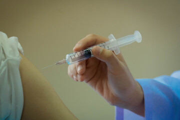 doctor is injecting a patient's arm with a vaccine