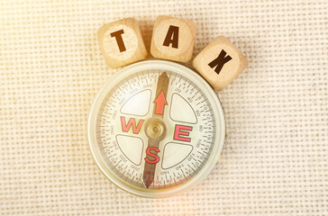 On the table is a compass and cubes with the inscription - TAX