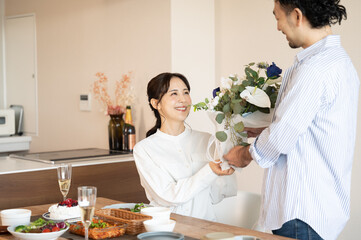 Obraz na płótnie Canvas 誕生日や記念日に花束を受け取る美しい日本人女性と男性 カップル 夫婦 1