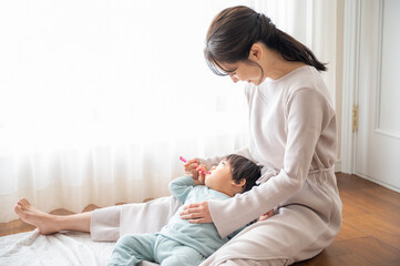 子どもの仕上げ磨き(ハミガキ)をするかわいいお母さん1