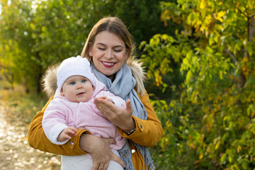 Happy beautiful mother spending time with her little baby girl in nature.