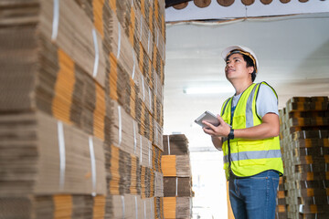 Warehouse worker courier inspecting checklist stock cardboard boxes for sale.