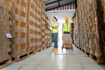 Teamwork of Workers In Warehouse preparing goods cardboard boxes on a pallet in warehouse for...
