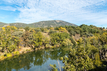 Fototapeta na wymiar Lozoya river, with the colors of autumn, as it passes through the Sierra de Guadarrama in the province of Madrid