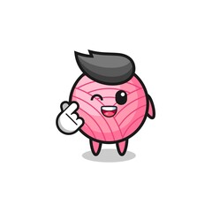 yarn ball character doing Korean finger heart