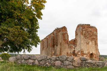 ruins of an ancient church towering on a green hill next to the cemetery of the knights