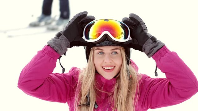 young girl snowboarder is smiling on the top of the mountain