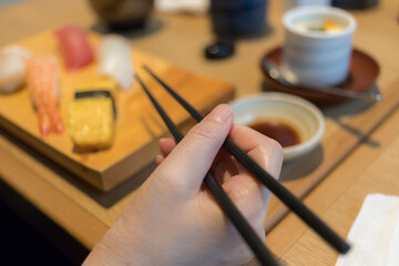 Fototapeta na wymiar 和食レストランで寿司ランチを食べる女性の様子