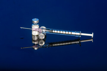 Syringe with vials and Needle on blue background