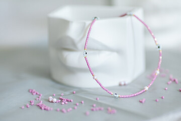 Pink delicate choker with daisies, stylish jewelry for women. White flower pot in the form of lips.