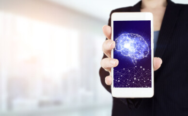 Digital Brain Artificial intelligenceHand hold white smartphone with digital hologram Brain sign on light blurred background. Data mining technology on a virtual panel.
