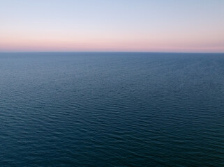 Aerial view of the endless sea surface in calm windless weather on a late summer evening.
