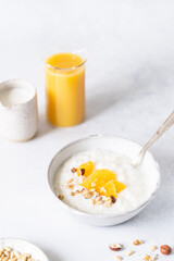Fresh porridge on nut milk with baked oranges, orange jam and nuts on a gray background. Healthy breakfast, healthy food