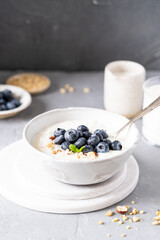 Fresh porridge on nut milk with baked oranges, orange jam and nuts on a gray background. Healthy breakfast, healthy food