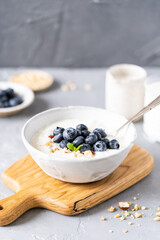 Fresh porridge on nut milk with baked oranges, orange jam and nuts on a gray background. Healthy breakfast, healthy food
