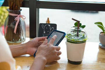 Woman hand holding and use credit card to payment drinks in cafe shop,online shopping from home ,...