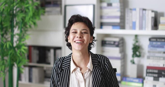 Businesswoman participates in online seminars or conferences. Cute short hair business woman pays attention to listen to speaker and laugh with funny and satisfying action during discussion.