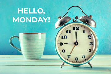 Hello, Monday Inspirational greeting card with a vintage alarm clock and a cup of coffee on a teal...