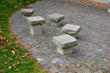 benches in the shape of mushrooms made of solid carved stone. connection of block and stone slabs, for paving near the house. chairs firmly situated in groups of five