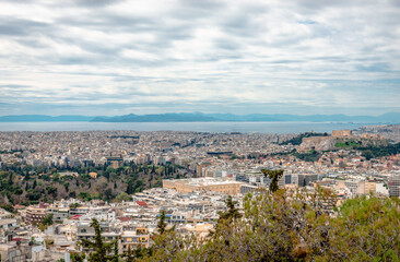 Fototapeta na wymiar Panoramic view of Athens from Lycabettus Hill. From left to right, the National Garden, the Greek Parliament and the Acropolis. Faliron, Piraeus and the Saronic Gulf are in the background.