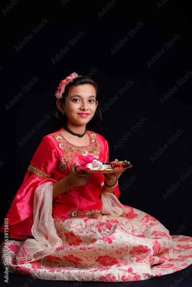 Poster Cute Indian little girl holding diya or oil lamps for Diwali Celebration.