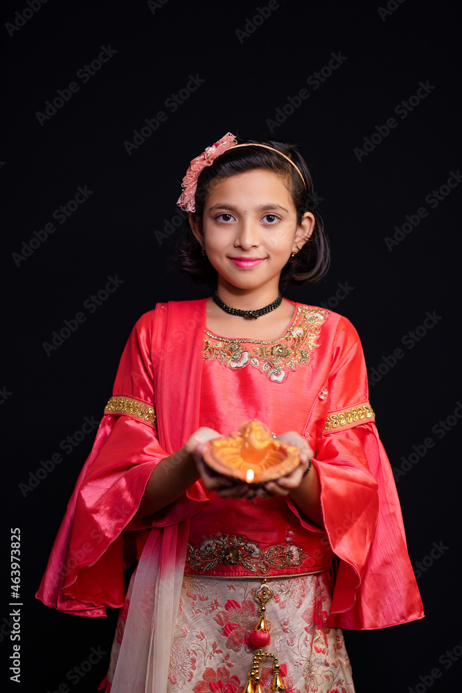 Poster Cute Indian little girl holding diya or oil lamps for Diwali Celebration.