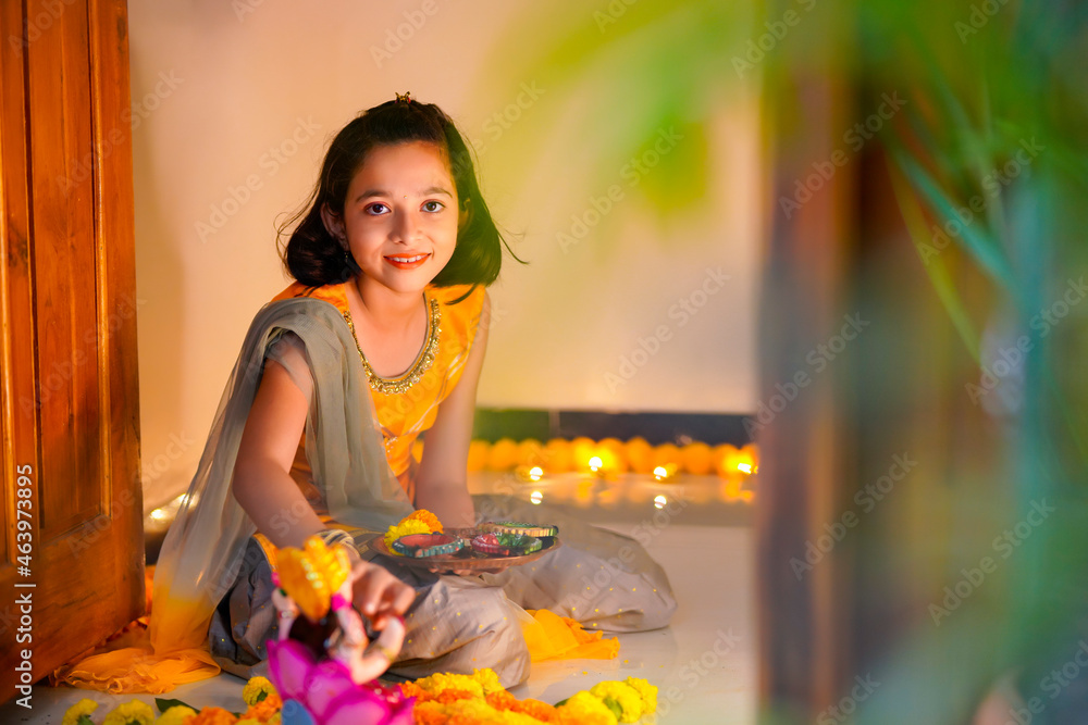 Canvas Prints Cute indian little girl making decoration with flower and oil lamp for diwali festival at home.