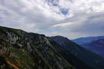 Fototapeta premium single alpine hut on the top from a huge rocky mountain with clouds