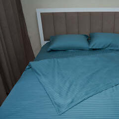 A large bed with blue bedding(linens)