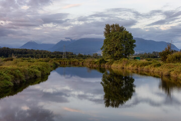 River in a city park. Colorful Summer Sunset. Colony Farm Regional Park, Port Coquitlam, Vancouver, British Columbia, Canada.
