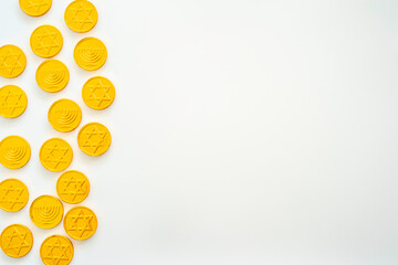 Chocolate coins with Jewish symbols on white background. Menorah and Star of David. Top view. Free space for text. Hanukkah background.