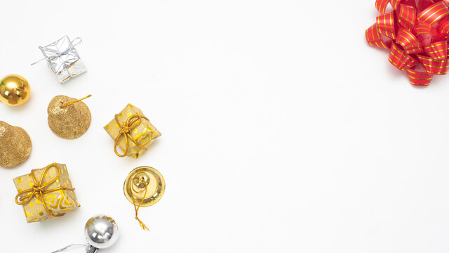Golden christmas accessories  and red ribbon on white background top view copy space