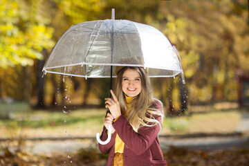 Beautiful woman with an umbrella in the rain in the autumn park. Copy Space. 