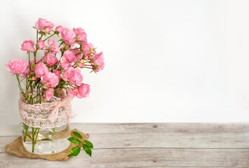 Beautiful Pink Roses in Glass Vase on a Wooden Background  .Home Decoration Elements 