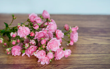 Fototapeta na wymiar Beautiful Pink Roses on a Wooden Background 