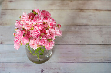 Beautiful Pink Roses in Glass Vase on a Wooden Background  .Home Decoration Elements 